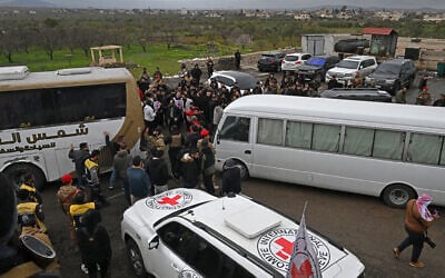 Security personnel and officials gather next to buses with prisoners on board during an exchange of prisoners ceremony between Syrian authorities and Druze fighters, on the outskirts of Sweida on February 26, 2026. (LOUAI BESHARA / AFP) Security personnel and officials gather next to buses with prisoners on board during an exchange of prisoners ceremony between Syrian authorities and Druze fighters, on the outskirts of Sweida on February 26, 2026. (LOUAI BESHARA / AFP)