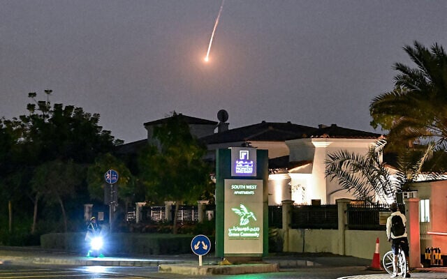A cyclist watches as a projectile falls over Dubai on February 28, 2026. (Photo by AFP) A cyclist watches as a projectile falls over Dubai on February 28, 2026. (Photo by AFP)