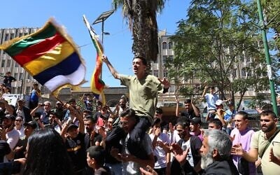People chant slogans while waving the Druze flag during a weekly rally in Sweida, southern Syria, on September 20, 2025. (AP/Fahd Kiwan) People chant slogans while waving the Druze flag during a weekly rally in Sweida, southern Syria, on September 20, 2025. (AP/Fahd Kiwan)