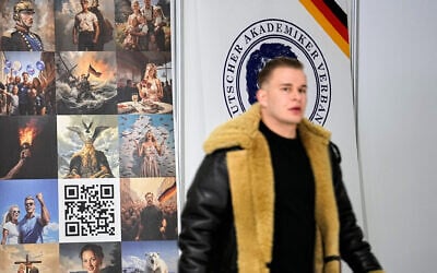 A party member walks in front of a stand during the re-founding of the AfD youth organization as "Generation Deutschland" in Giessen, Germany, November 29, 2025. (Martin Meissner/AP)
