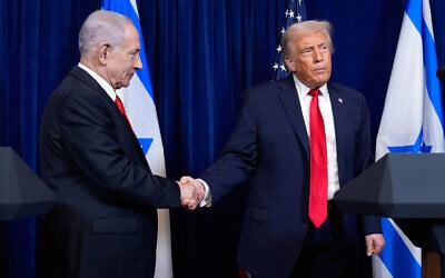 US President Donald Trump (R) shakes hands with Prime Minister Benjamin Netanyahu as Trump listens to a question from a reporter at the end of a news conference at Mar-a-Lago, on December 29, 2025, in Palm Beach, Florida. (AP Photo/Alex Brandon)