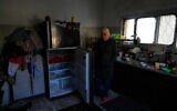 Palestinian laborer Shuhrat Barghouthi shows her empty fridge, saying that she struggles to buy food after Israel revoked work permits for Palestinians in the West Bank city of Tulkarem, January 18, 2026. (Nasser Nasser/AP)