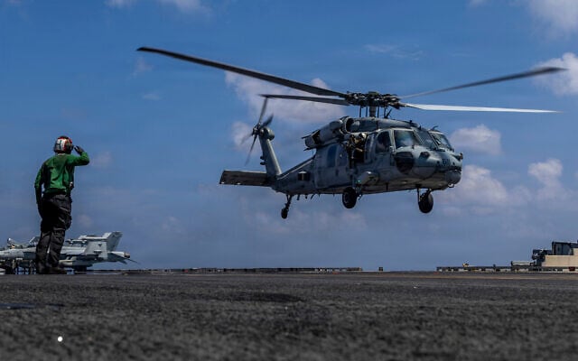 This handout image from the US Navy shows Capt. Daniel Keeler, the commanding officer of the Nimitz-class aircraft carrier USS Abraham Lincoln, flying an MH-60R Sea Hawk helicopter in the Indian Ocean on Jan. 23, 2026. (Mass Communication Specialist Seaman Daniel Kimmelman/US Navy via AP)