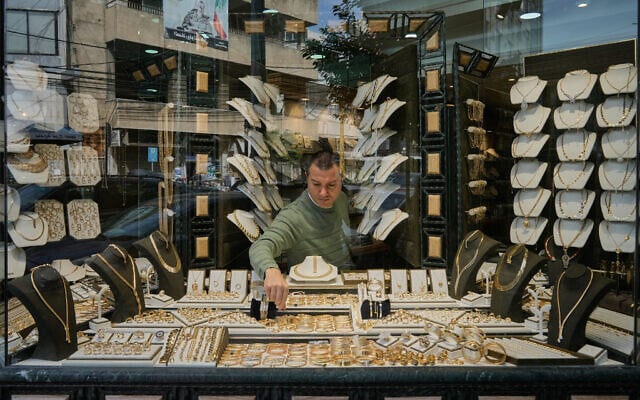 A Lebanese jeweler arranges gold ornaments at his shop's storefront in the Beirut suburb of Bourj Hammoud, Lebanon, February 2, 2026. (AP/Bilal Hussein)