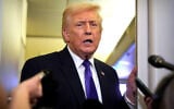 US President Donald Trump speaks to reporters as he flies aboard Air Force One from Joint Base Andrews, Maryland, to West Palm Beach, Florida, February 6, 2026. (AP Photo/Mark Schiefelbein)