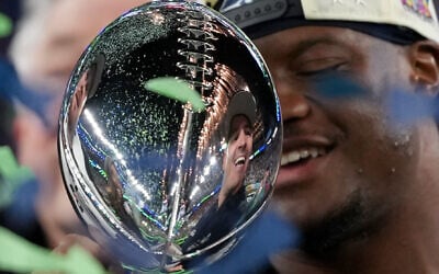 Seattle Seahawks head coach Mike MacDonald is reflected in the Lombardi Trophy after a win over the New England Patriots in the NFL Super Bowl 60 football game in Santa Clara, California, February 8, 2026, (Matt Slocum/AP)