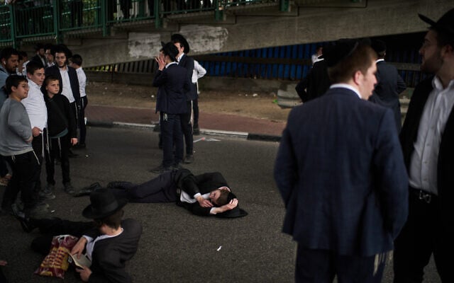 Ultra-Orthodox Jewish men block a road as they take part in a protest against military conscription in Bnei Brak, Israel, February 9, 2026. (AP Photo/Leo Correa)