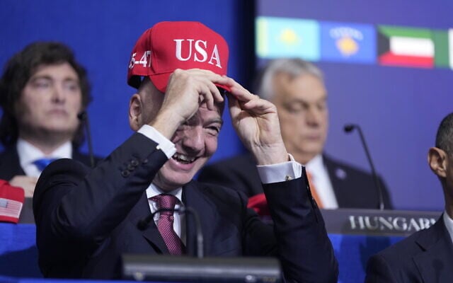 Giovanni Vincenzo Infantino, president of FIFA, tries out a USA hat during a Board of Peace meeting at the U.S. Institute of Peace, Thursday, Feb. 19, 2026, in Washington. (AP Photo/Mark Schiefelbein) Giovanni Vincenzo Infantino, president of FIFA, tries out a USA hat during a Board of Peace meeting at the U.S. Institute of Peace, Thursday, Feb. 19, 2026, in Washington. (AP Photo/Mark Schiefelbein)