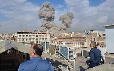 People watch as smoke rises on the horizon after an explosion in Tehran, Iran, February 28, 2026. (AP)