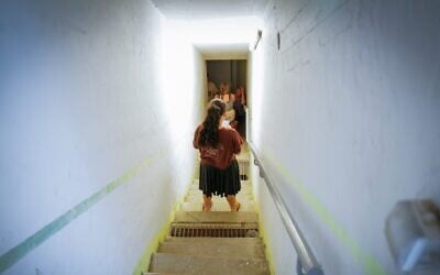 People take cover as siren warns of incoming missiles fired from Iran, at a public bomb shelter in Katzrin, northern Israel, June 19, 2025. (Michael Giladi/Flash90)