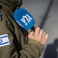 An IDF soldier serving at Army Radio holds a microphone in Jerusalem, December 22, 2025. (Yonatan Sindel/Flash90)