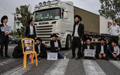 Ultra-Orthodox Jewish men block a road during a protest against the jailing of yeshiva students at the Gilat junction, near the southern Israeli city of Ofakim, February 9, 2026. (Tsafrir Abayov/Flash90)
