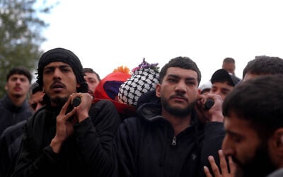 Mourners carry the body of Palestinian-American Nasrallah Muhammad Abu Siam, 19,  who was allegedly shot by settlers, during his funeral in the West Bank village of Mukhmas, east of Ramallah, February 19, 2026. (Flash90)