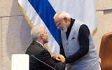 Opposition leader Yair Lapid greets Indian Prime Minister Narendra Modi at the Knesset in Jerusalem during Modi’s official visit to Israel on February 25, 2026. (Yonatan Sindel/Flash90)