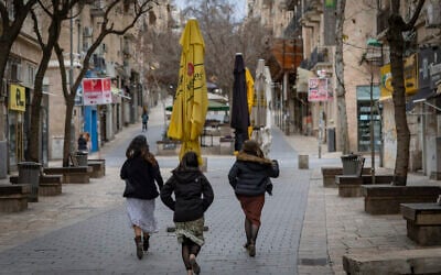 Pedestrians run for cover in central Jerusalem following sirens warning of incoming missiles from Iran, on February 28, 2026. (Yonatan Sindel/Flash90)