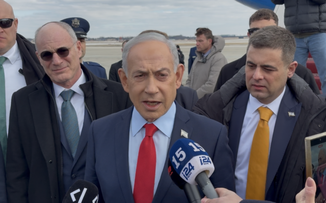 Prime Minister Benjamin Netanyahu speaks to reporters on the tarmac of Joint Base Andrews in Maryland ahead of his return to Israel, February 12, 2026. (Lazar Berman/The Times of Israel)