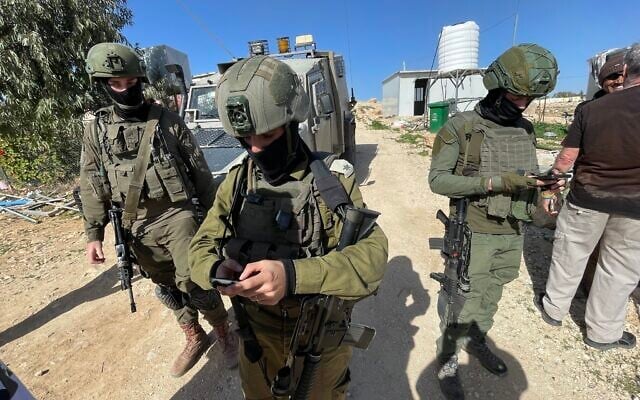 IDF soldiers read out a closed military zone order to coexistence activists who had come to plant trees in the Palestinian West Bank hamlet of Umm al-Khair, February 2, 2026. (Jeremy Sharon / The Times of Israel)