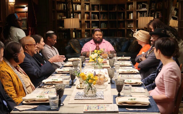 Black and Jewish chef, writer, educator and food historian Michael W. Twitty sits at the head of the table at an interfaith seder attended by members of the Black and Jewish communities in this undated photo. (Courtesy of Sara Wolitzky)