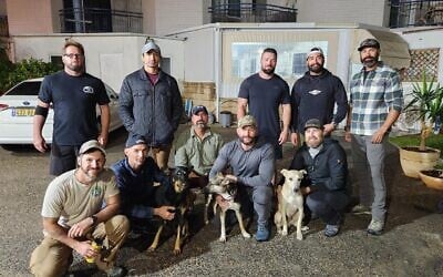 US soldiers pose with three of the ten abandoned dogs from the Gaza border that they will adopt. (Let the Animals Live)