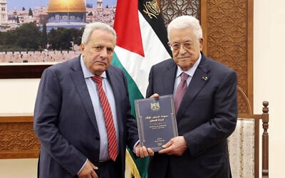 Palestinian Authority President Mahmoud Abbas receives a draft of the State of Palestine's interim constitution from counselor Muhammad al-Hajj Qasim in Ramallah on February 5, 2026. (Wafa)