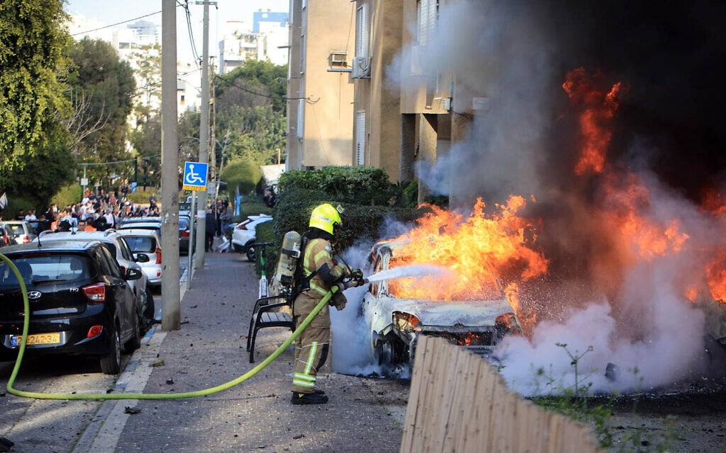 Firefighters extinguish a burning car in Tel Aviv after an Iranian missile barrage towards central Israel on March 3, 2026. (Fire and Rescue Service)