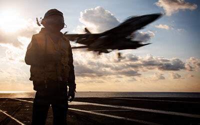 A US service member stands by as an F/A-18F Super Hornet aircraft lands on the flight deck aircraft carrier USS Gerald R. Ford while operating in support of Operation Epic Fury in the Eastern Mediterranean Sea, March 2, 2026. (US Navy)