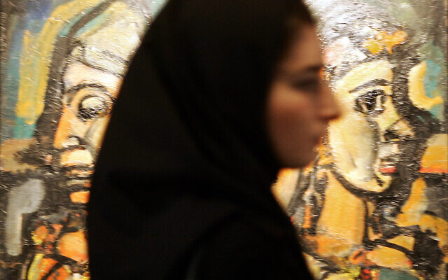 An Iranian woman passes by Georges Rouault painting "Trio-Cirque" (1928) displayed at the Modern Art Movement exhibition at Tehran's Museum of Contemporary Art, September 1, 2005. (BEHROUZ MEHRI / AFP)