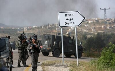 Illustrative: Israeli border police keep watch on the main road leading to the Palestinian village of Duma in the West Bank, on April 5, 2016.  (MENAHEM KAHANA / AFP)