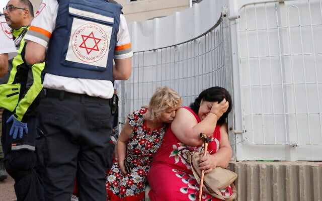 Illustrative: Rescue teams help shocked residents in a targeted residential neighborhood in the southern city of Ashkelon on May 11, 2021, after rockets were fired by Hamas from the Gaza Strip. (JACK GUEZ / AFP) Illustrative: Rescue teams help shocked residents in a targeted residential neighborhood in the southern city of Ashkelon on May 11, 2021, after rockets were fired by Hamas from the Gaza Strip. (JACK GUEZ / AFP)