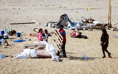 Illustrative: Displaced people who had taken refuge on Beirut's Ramlet al-Baida beach, gather their belongings after receiving orders from the Lebanese Internal Security Forces to dismantle the temporary encampment and to move to proper shelters in the capital, on October 31, 2024. (IBRAHIM AMRO / AFP) Illustrative: Displaced people who had taken refuge on Beirut's Ramlet al-Baida beach, gather their belongings after receiving orders from the Lebanese Internal Security Forces to dismantle the temporary encampment and to move to proper shelters in the capital, on October 31, 2024. (IBRAHIM AMRO / AFP)