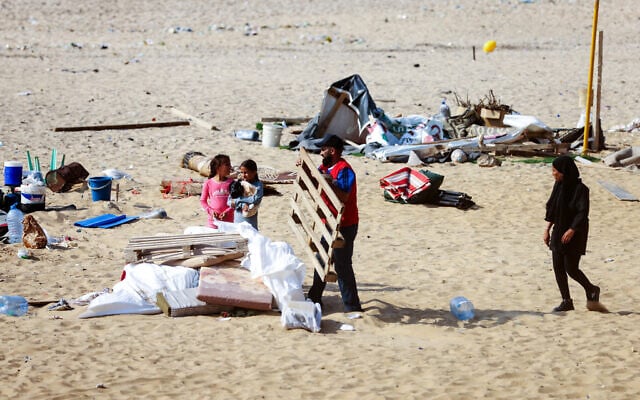 Illustrative: Displaced people who had taken refuge on Beirut's Ramlet al-Baida beach, gather their belongings after receiving orders from the Lebanese Internal Security Forces to dismantle the temporary encampment and to move to proper shelters in the capital, on October 31, 2024. (IBRAHIM AMRO / AFP) Illustrative: Displaced people who had taken refuge on Beirut's Ramlet al-Baida beach, gather their belongings after receiving orders from the Lebanese Internal Security Forces to dismantle the temporary encampment and to move to proper shelters in the capital, on October 31, 2024. (IBRAHIM AMRO / AFP)