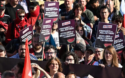 Participants display placards of Germany's The Left (Die Linke) party reading 'Freedom for Palesting - End the Occupation and Genocide' during a demonstration under the motto 'Draw the red line with us: Together for Gaza!' in Berlin on September 27, 2025. (Photo by RALF HIRSCHBERGER / AFP)