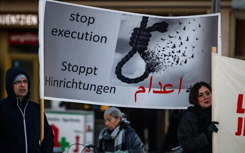 Protesters display a banner calling for a halt to executions in Iran during a rally in Berlin, Germany, on January 10, 2026, in support of the Iran protests. (John MacDougall / AFP)