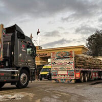 Humanitarian aid trucks enter on the Egyptian side of the Rafah border crossing with the Gaza Strip in northeastern Egypt on February 4, 2026.  (STR / AFP)