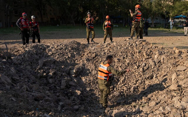 Rescue forces inspect a crater at the scene of an Iranian missile strike in Beersheba on March 2, 2026. (Maya Levin/AFP)