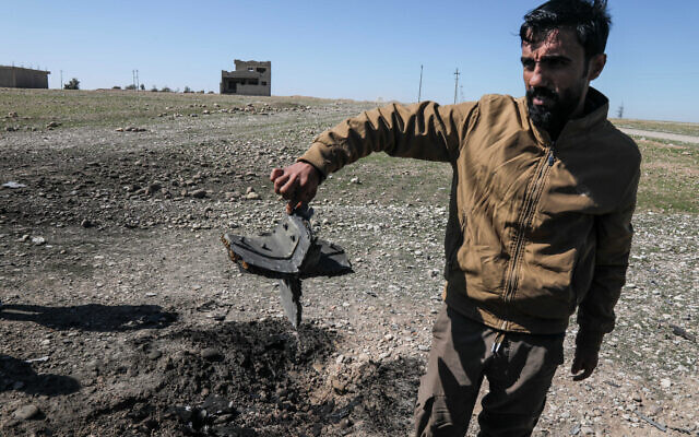 A man shows the remains of an Iranian drone that was reportedly aimed at Erbil International Airport and crashed outside Erbil, the capital of the autonomous Kurdish region of northern Iraq, on March 3, 2026. (Safin HAMID / AFP)