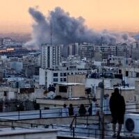 A person stands on the roof of a building looking at a plume of smoke rising after a strike on the Iranian capital Tehran, on March 3, 2026. (Atta Kenare/AFP)