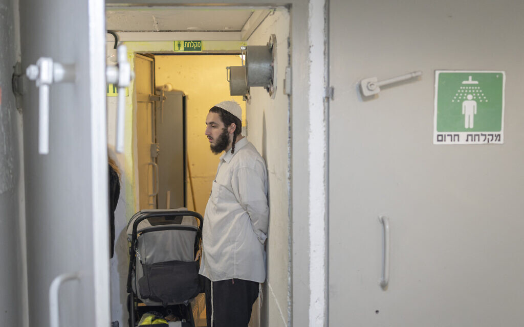 A man stands next to a stroller at a shelter after incoming missile sirens wailed in Tel Aviv on March 4, 2026. (Ilia YEFIMOVICH / AFP)