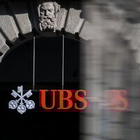 This photograph shows a sign of Swiss giant banking UBS at a branch in Zurich on March 4, 2026. (Fabrice COFFRINI / AFP)