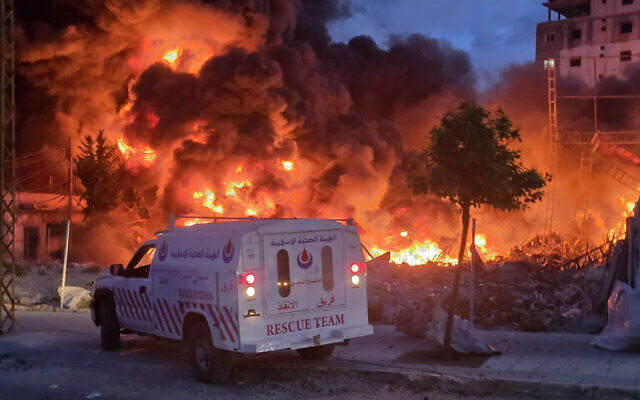 An ambulance is parked near a sweeping blaze following an Israeli strike on a solar farm and electricity generation facility in Lebanon's southern coastal city of Tyre on March 4, 2026. (Kawnat HAJU / AFP)