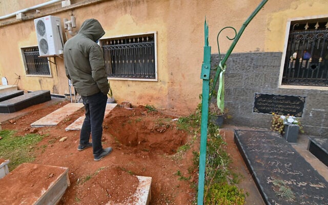 This photograph taken during a media tour organised by Hezbollah shows a man standing next to a dug-out grave reportedly during an Israeli military operation at a cemetery in Nabi Chit in the Beqaa Valley of Lebanon, on March 7, 2026. (FADEL itani / AFP) This photograph taken during a media tour organised by Hezbollah shows a man standing next to a dug-out grave reportedly during an Israeli military operation at a cemetery in Nabi Chit in the Beqaa Valley of Lebanon, on March 7, 2026. (FADEL itani / AFP)