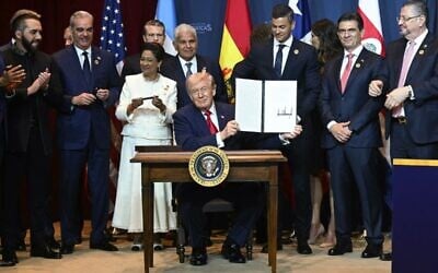 US President Donald Trump holds up a newly-signed proclamation at the "Shield of the Americas" Summit at Trump National Doral in Miami, Florida, March 7, 2026. (Saul Loeb / AFP)
