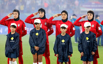 Iran's players salute during the national anthem before the AFC Women's Asian Cup Australia 2026 football match between Iran and Philippines in Gold Coast on March 8, 2026. (AFP)