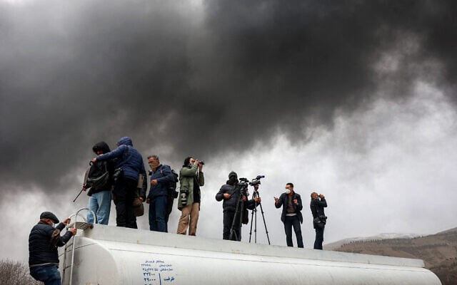 Journalists stand atop a fuel tanker as they cover a nearby ongoing fire following an overnight airstrike on the Shahran oil refinery in northwestern Tehran on March 8, 2026. (AFP) Journalists stand atop a fuel tanker as they cover a nearby ongoing fire following an overnight airstrike on the Shahran oil refinery in northwestern Tehran on March 8, 2026. (AFP)