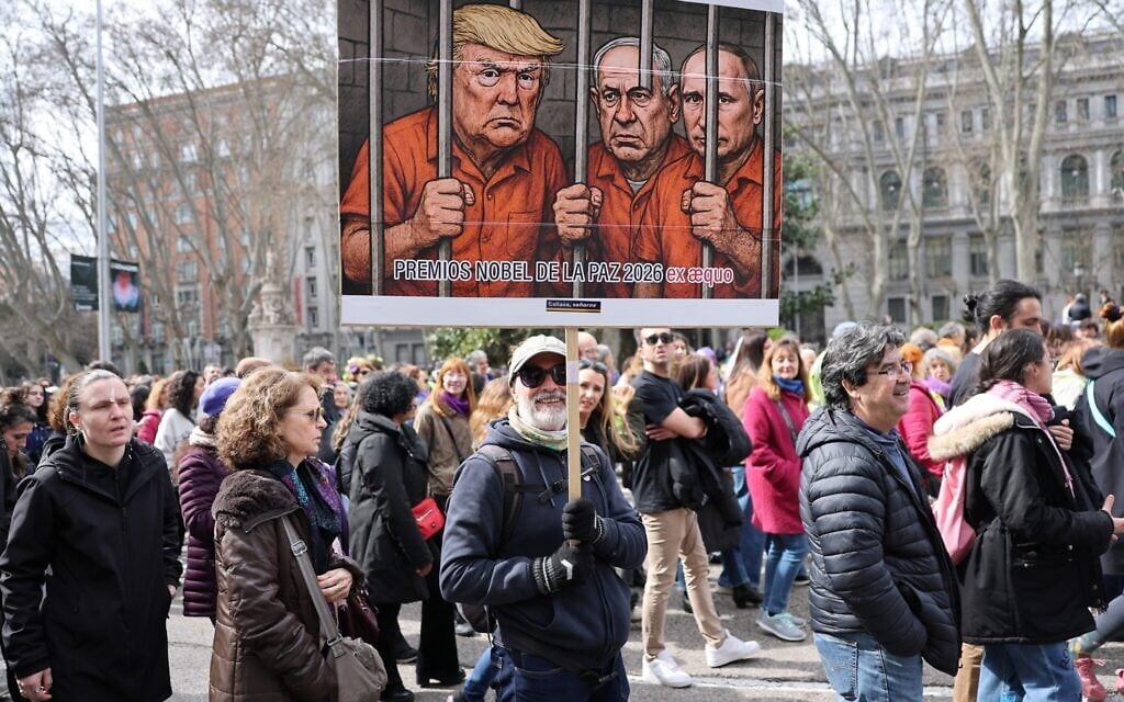 A man holds a banner mocking US President Donald Trump, Prime Minister Benjamin Netanyahu and Russia's President Vladimir Putin during a demonstration marking International Women's Day in Madrid on March 8, 2026. (Thomas COEX / AFP) A man holds a banner mocking US President Donald Trump, Prime Minister Benjamin Netanyahu and Russia's President Vladimir Putin during a demonstration marking International Women's Day in Madrid on March 8, 2026. (Thomas COEX / AFP)