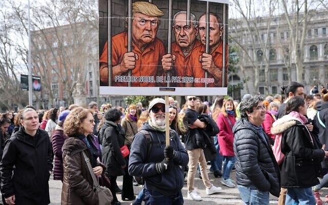 A man holds a banner mocking US President Donald Trump, Prime Minister Benjamin Netanyahu and Russia's President Vladimir Putin during a demonstration marking International Women's Day in Madrid on March 8, 2026. (Thomas COEX / AFP) A man holds a banner mocking US President Donald Trump, Prime Minister Benjamin Netanyahu and Russia's President Vladimir Putin during a demonstration marking International Women's Day in Madrid on March 8, 2026. (Thomas COEX / AFP)