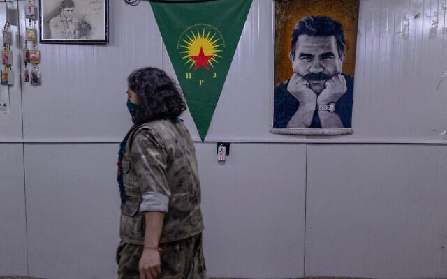 A female Kurdish fighter from the Iranian Kurdish armed faction Kurdistan Free Life Party (PJAK) passes a poster of Abdullah Ocalan, the jailed founder of the Kurdistan Workers' Party (PKK), at a site near the Iraqi border with Iran in Iraq's autonomous Kurdistan region, on March 8, 2026. (Photo by AFP) A female Kurdish fighter from the Iranian Kurdish armed faction Kurdistan Free Life Party (PJAK) passes a poster of Abdullah Ocalan, the jailed founder of the Kurdistan Workers' Party (PKK), at a site near the Iraqi border with Iran in Iraq's autonomous Kurdistan region, on March 8, 2026. (Photo by AFP)