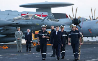 French President Emmanuel Macron (C) visits the French aircraft carrier Charles de Gaulle, deployed to the Mediterranean following Iranian drone strikes on Cyprus on the Mediterranean Sea, on March 9, 2026, on the sidelines of his trip to Cyprus to discuss regional security. (Gonzalo Fuentes / POOL / AFP)