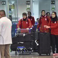 Members of Iran's women's football team walk with their luggage as they arrive at the Kuala Lumpur International Airport after taking part in the AFC Women's Asian Cup Australia 2026 tournament in Australia, in Sepang on March 11, 2026. (ARIF KARTONO / AFP)