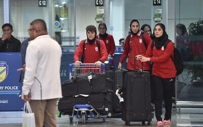 Members of Iran's women's football team walk with their luggage as they arrive at the Kuala Lumpur International Airport after taking part in the AFC Women's Asian Cup Australia 2026 tournament in Australia, in Sepang on March 11, 2026. (ARIF KARTONO / AFP)